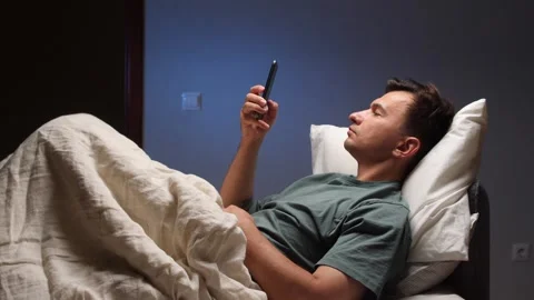 Man using smartphone in bed at night, insomnia and sleep problems Stock Footage 317725324
