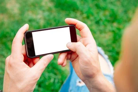 Man using smartphone with blank screen outdoors, closeup. Mock up for design Stock Photos