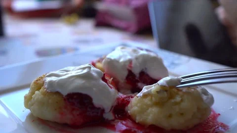 Man using smartphone at breakfast time. Cheese pancakes, minicakes and berry jam Video stock 71766059