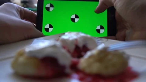 Man using smartphone at breakfast time. Cheese pancakes, minicakes and berry jam Video stock 71964644