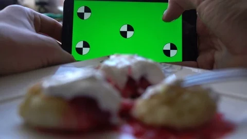 Man using smartphone at breakfast time. Cheese pancakes, minicakes and berry jam Stock Footage 71964856