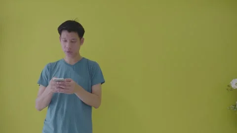 Man Using Smartphone in a Bright Yellow Room Stock Footage 314637548