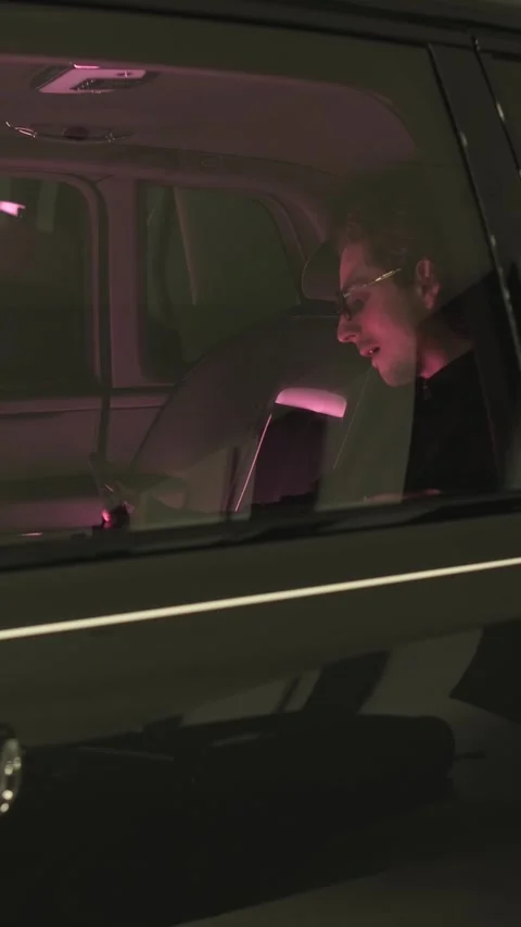 Man using smartphone in car at night, illuminated by screen light Stock Footage 335132121