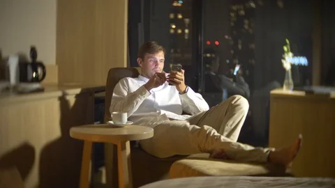 Man using a smartphone, on a chair Stock Footage 86486934