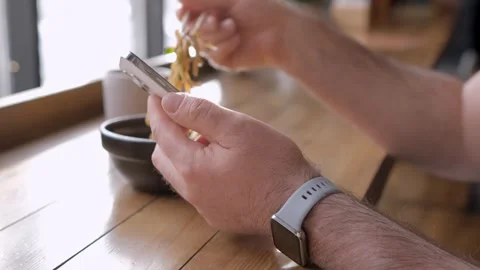 Man using a smartphone in a Chinese restaurant. Male spending time at cafe with Stock Footage 265207526