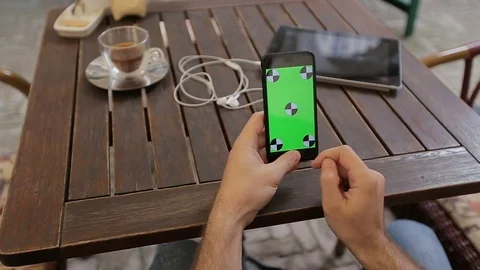 Man using smartphone in Coffee Shop. Smatrphone with Green Screen Stock Footage 76834484