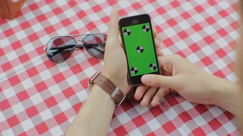 Man using smartphone in Coffee Shop. Smartphone with Green Screen Stock Footage 76835125