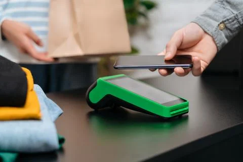 Man using smartphone for contactless payment in the store Stock Photos