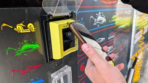 Man Using Smartphone For Contactless Payment At Car Wash Terminal 写真素材