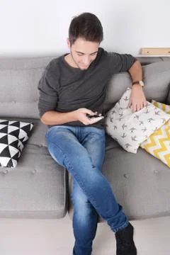 Man using smartphone on couch. Stock Photos