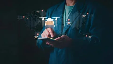 Man using smartphone with drone flying and world map Stock Photos