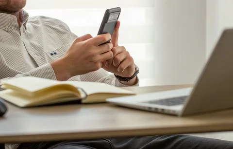 Man using smartphone during working at office Stock Photos