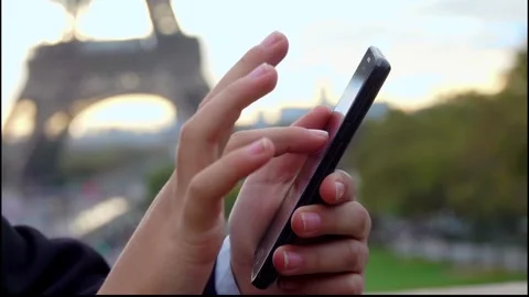 Man Using a Smartphone with the Eiffel Tower in the Background Stock Footage 314376719