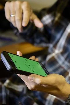 Man using smartphone with focus on screen indoors Stock Photos