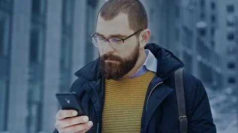 Man using smartphone in front of business center Stock Footage 71982226