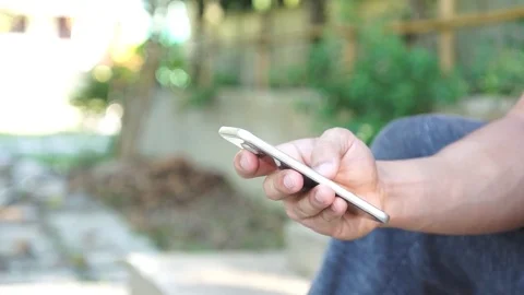 Man using a smartphone in a garden. Stock Footage 83912381