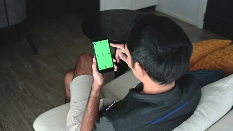 A man using a smartphone with a green chroma key on the screen. Stock-Footage 146455193