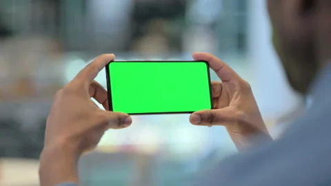 Man Using Smartphone with Green Chroma Key Screen, Rear View Stock Footage 146484084
