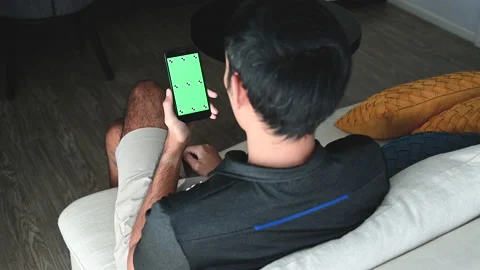 A man using a smartphone with a green chroma key on the screen. Stock-Footage 146682442