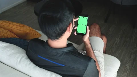 A man using a smartphone with a green chroma key on the screen. Stock Footage 146682574