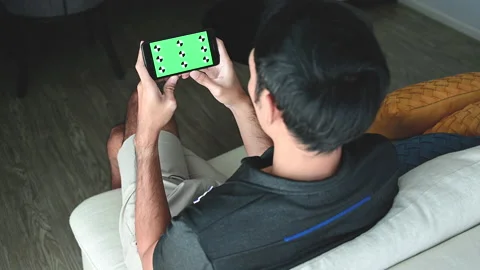 A man using a smartphone with a green chroma key on the screen. Stock-Footage 146682697