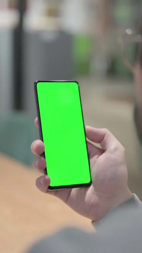 Man using Smartphone with Green Chroma Screen, Vertical Video Stock Footage 339581150