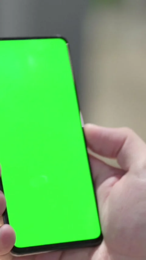 Man using Smartphone with Green Chroma Screen, Vertical Video Stock Footage 339581290