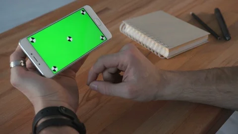 Man using smartphone with green screen at table Stock Footage 87868250