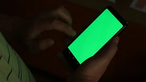 Man using a smartphone with green screen at night Video Stock Footage 111895155