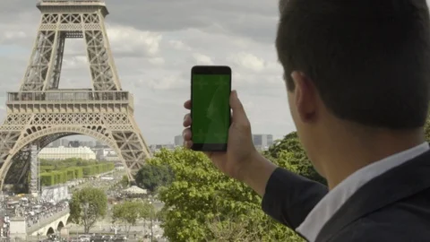 Man using smartphone with Green Screen at Eiffel Tower, Touchscreen with Video stock 111924360