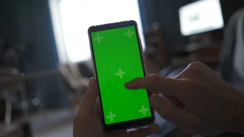 Man using smartphone with green screen at home, watching news Stock Footage 115435438