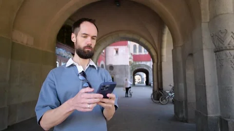 Man Using Smartphone on Historic City Street. Subotica, Serbia Stock Footage 308636415