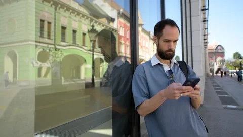 Man Using Smartphone on Historic City Street. Subotica, Serbia Stock Footage 308636435
