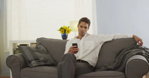 Man using smartphone at home on couch after work Video stock 42688101