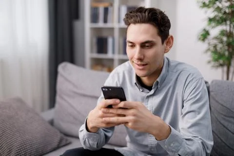 Man using smartphone at home Stock Photos