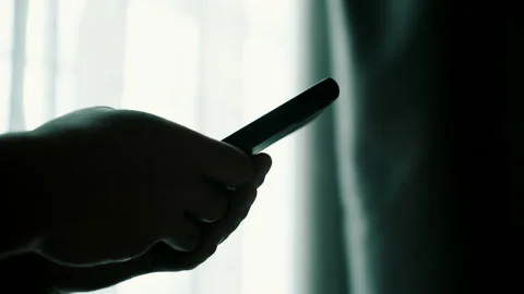 Man using smartphone at home with window background Stock Footage 141554345