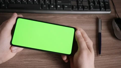 Man Using Smartphone  in Horizontal Mode with Green Mock-up Screen, Doing Swi Stock-Footage 138418142