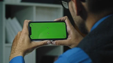 Man Using Smartphone in Horizontal Mode with Green Mock-up Screen Stock Footage 165342088