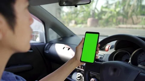 Man using a smartphone inside the car. Chromakey smartphone with green screen. A Stock Footage 170589222