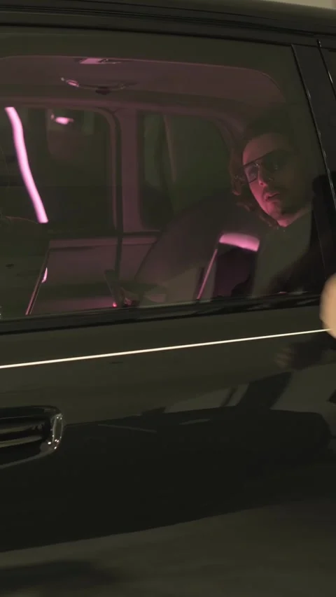 Man using smartphone inside car at night, illuminated by screen light Stock Footage 335135710