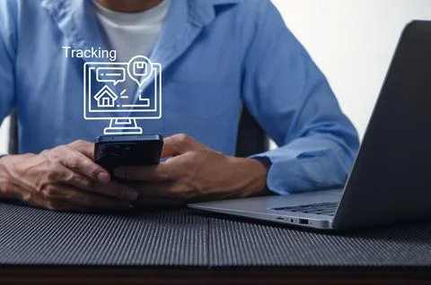 Man Using Smartphone for Location Tracking with Laptop Nearby Stock Photos