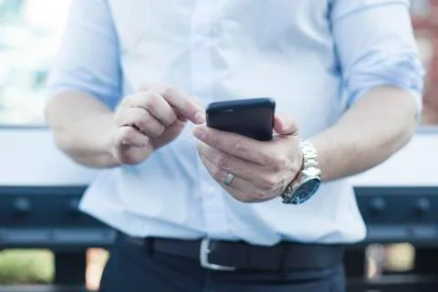 Man using smartphone, mid section Stock Photos