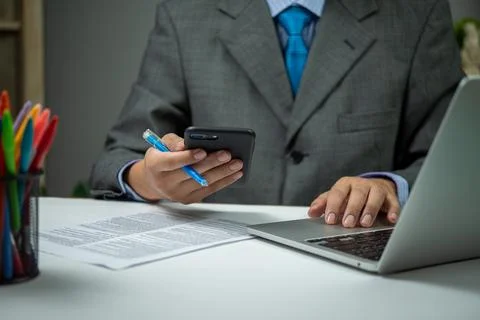 Man using smartphone mobile application and document information with lapto.. Stock Photos