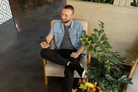 Man using smartphone in modern space for online education or remote work du.. Stockfoto's