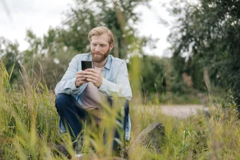 Man using smartphone in nature Stock Photos