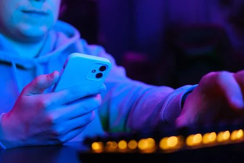 Man using smartphone in neon light Stock Photos
