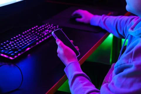 Man using smartphone in neon light Stock Photos