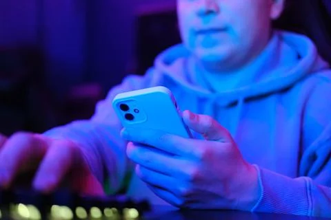 Man using smartphone in neon light Stock Photos