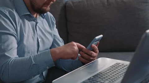 Man using smartphone next to laptop during work Stock Footage 340202622