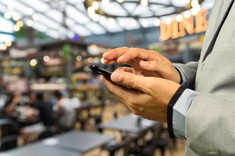 Man using Smartphone or Cellphone in caf or Restaurant Stock Photos